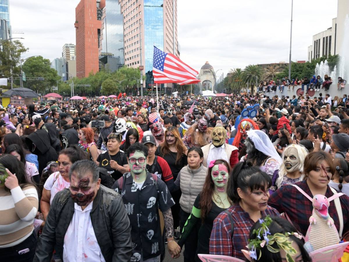 Multitud de personas disfrazadas desfilando y espectadores observando tras las vallas en el Centro Histórico.