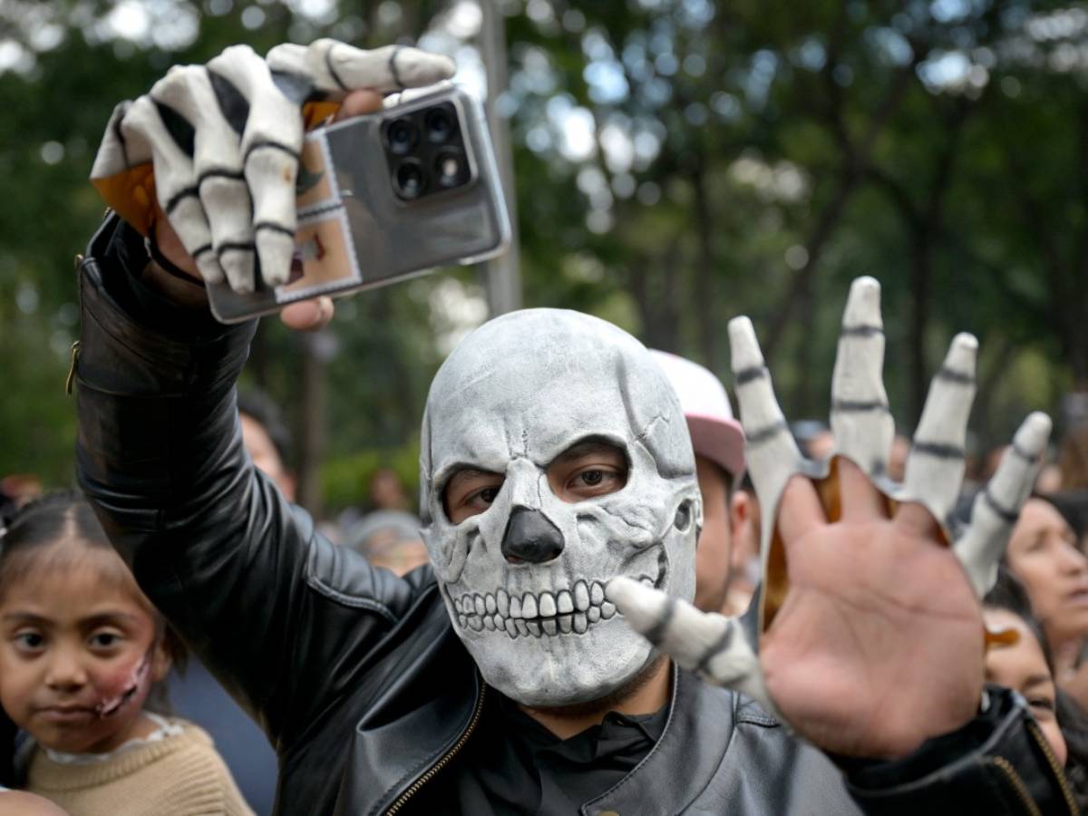 Asistentes disfrazados de zombies caminando por las calles del Centro Histórico de la Ciudad de México.
