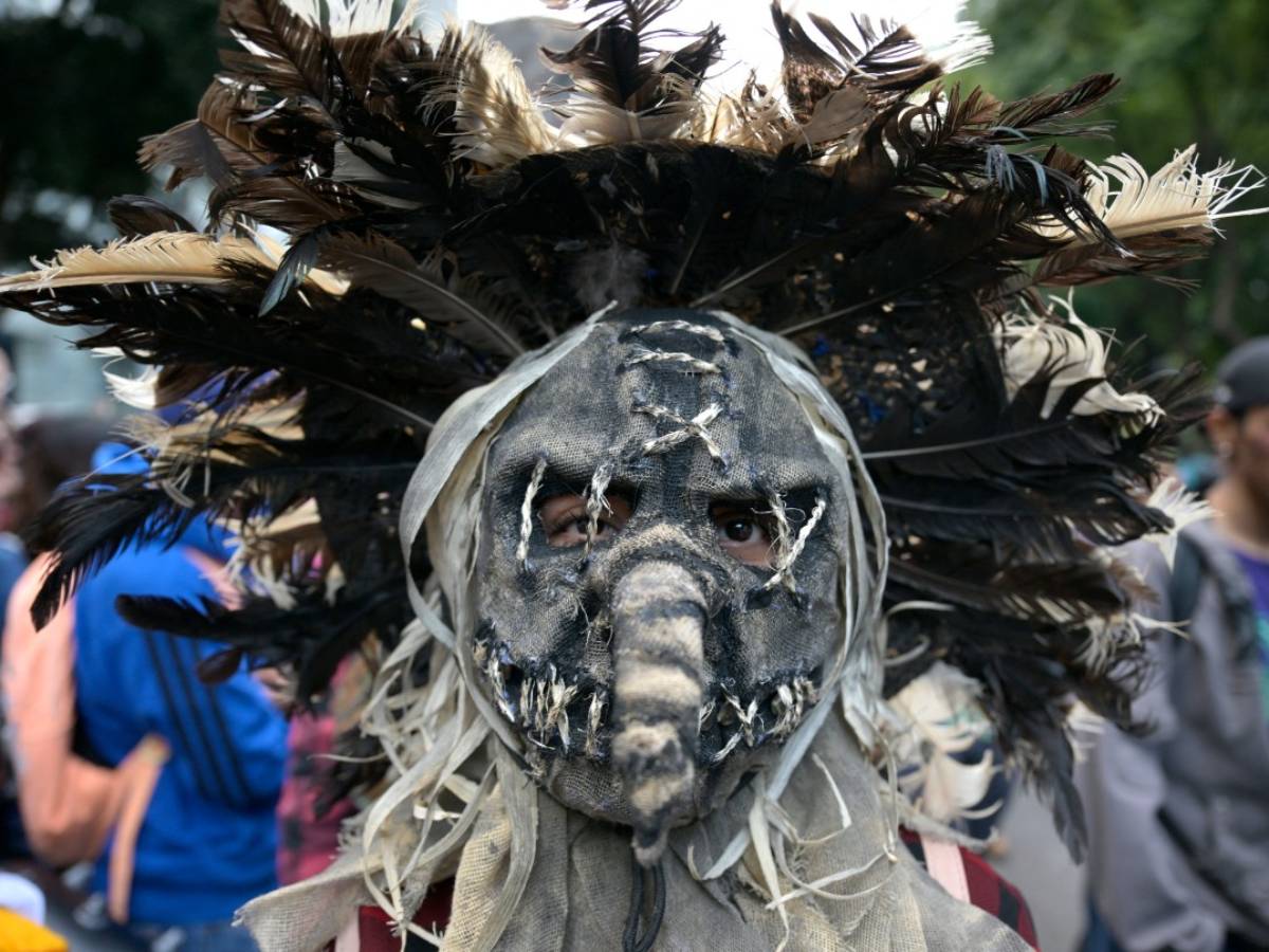 Participantes caracterizados con disfraces temáticos de zombies y monstruos clásicos durante el desfile urbano.