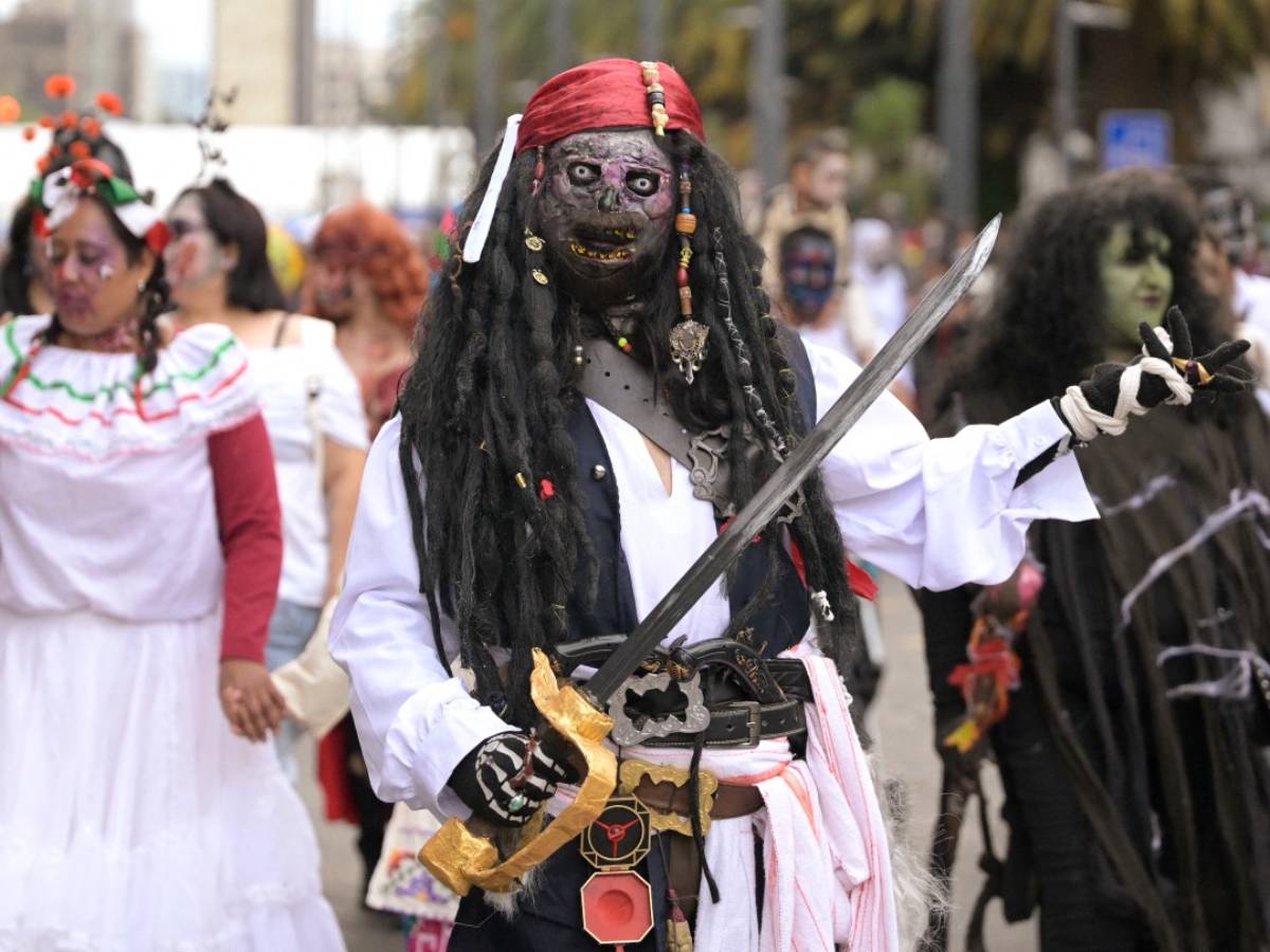 Punto de partida del desfile en el Monumento a la Revolución con multitud avanzando hacia la Plaza de la Constitución.