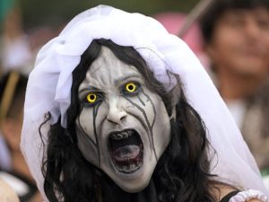Participantes caracterizados como zombies caminando por las calles del centro de la Ciudad de México.