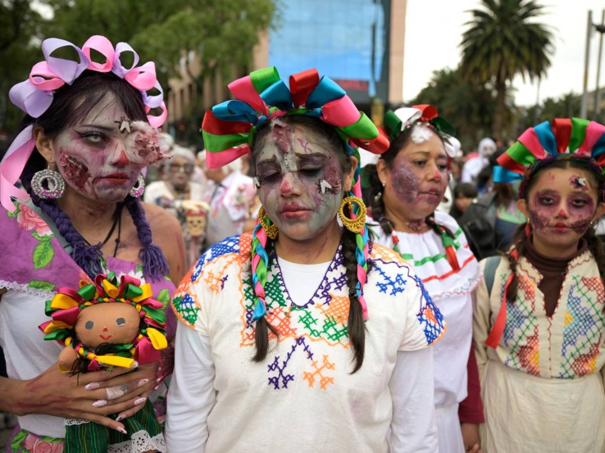 Grupo de mujeres caracterizadas como muñecas Lele y vestidas con trajes tradicionales mexicanos y maquillaje de zombie.