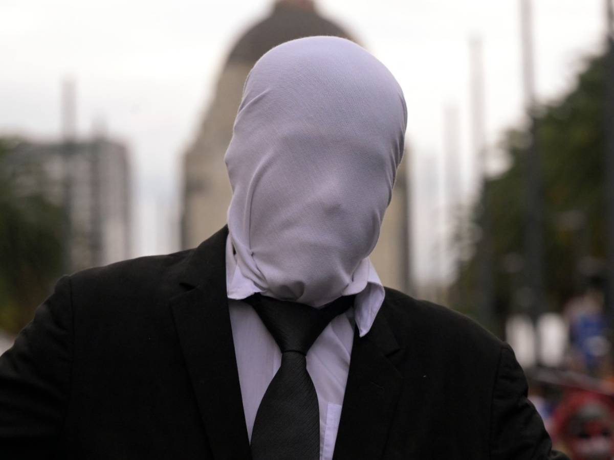 Persona caracterizada como Slenderman vistiendo traje negro, corbata y una máscara blanca que le cubre el rostro.