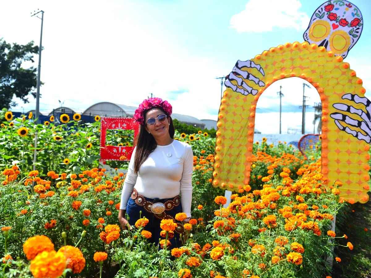 Diana Paola García, encargada del vivero, sonriendo junto a las exhibiciones de plantas durante el evento.