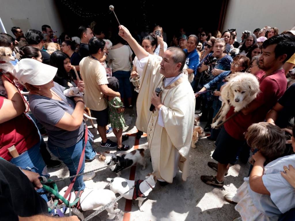 Sacerdote católico realizando la bendición de perros y mascotas reunidos junto a sus familias en Zapopan.