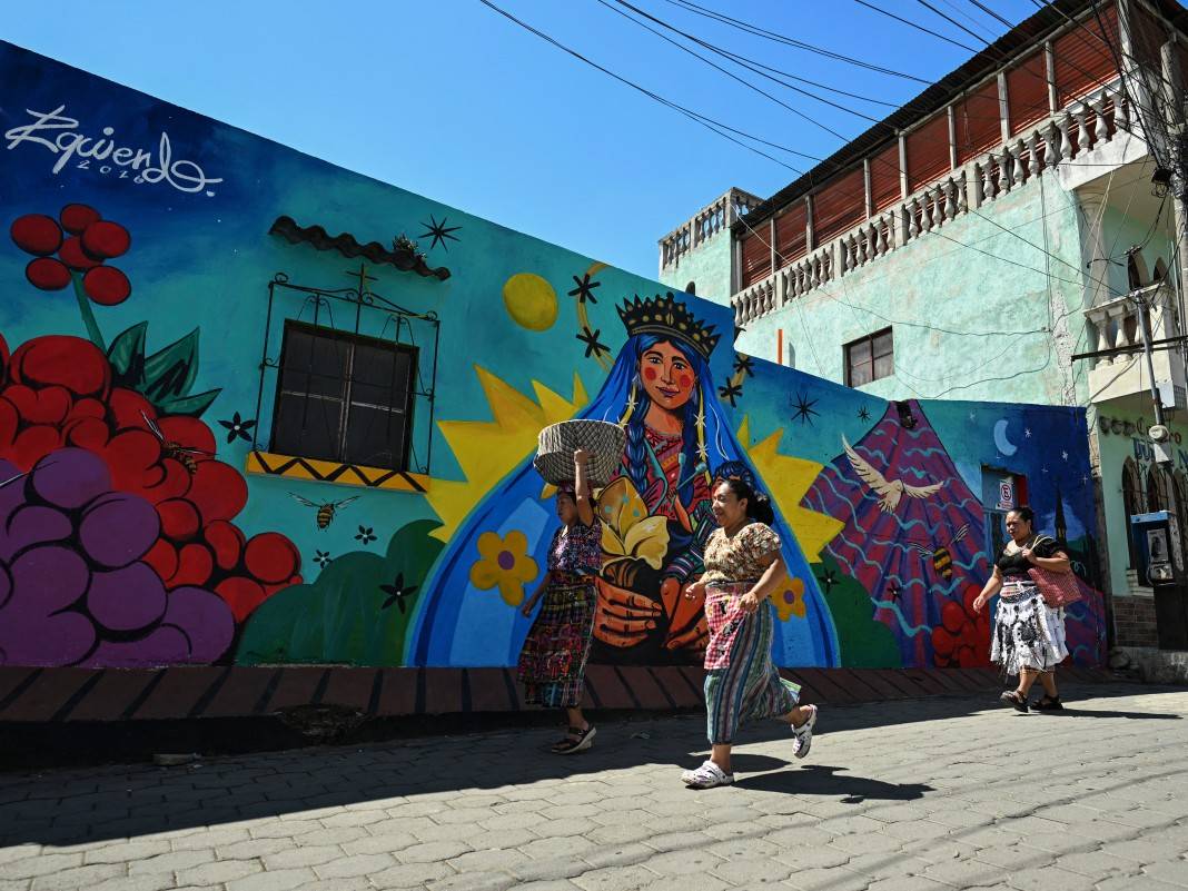 Detalle del rostro de una Virgen en un mural con la mirada orientada directamente hacia la calle y los transeúntes.