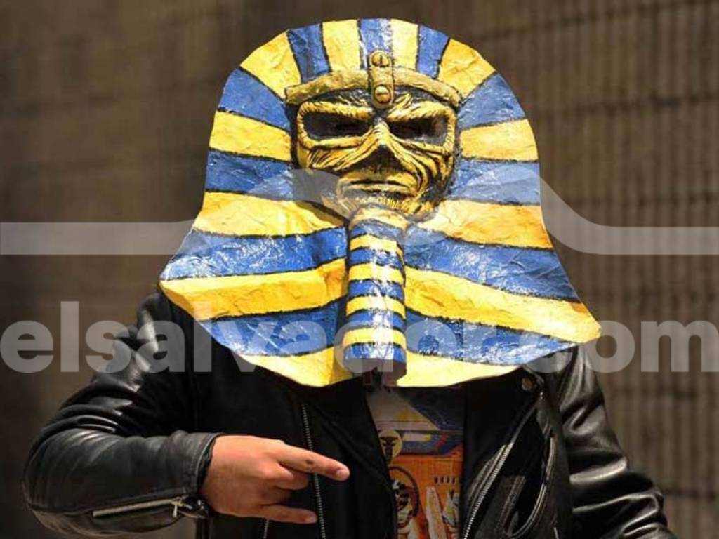 Fanático vistiendo una máscara de faraón en homenaje al concepto visual del álbum Powerslave de Iron Maiden