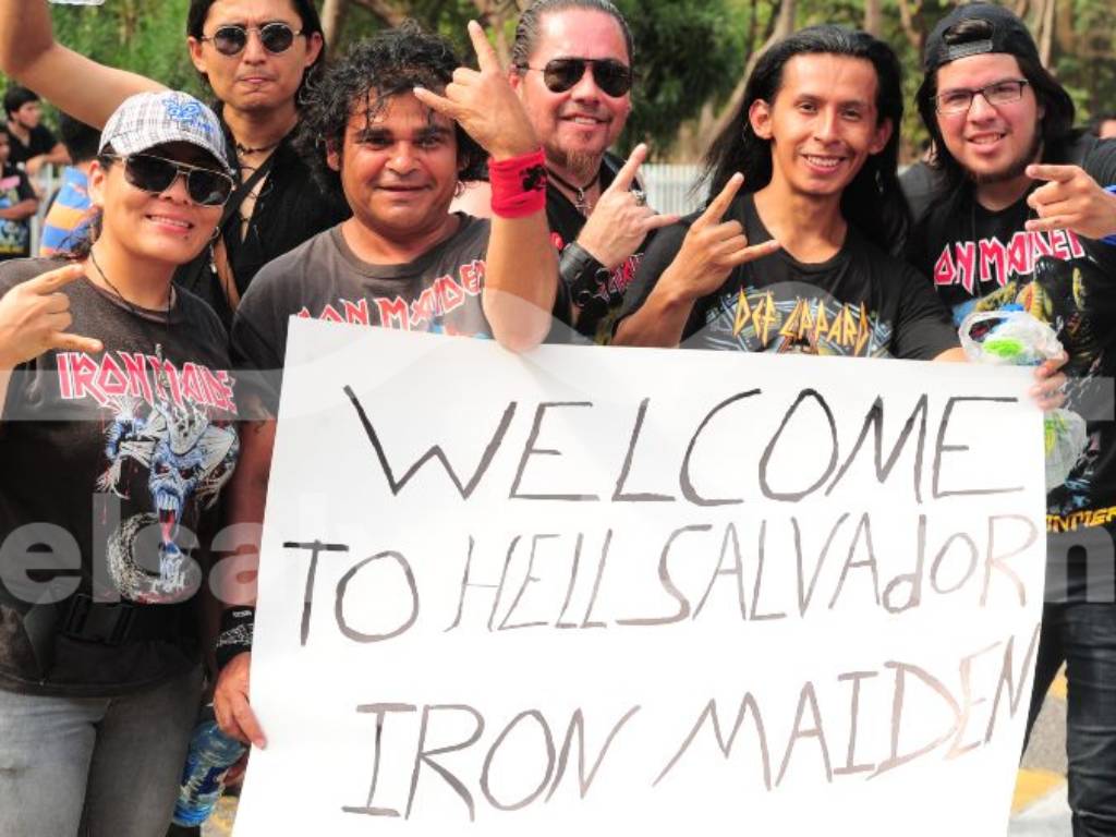 Fanáticos reunidos vistiendo camisetas alusivas a Iron Maiden y portando carteles de bienvenida.