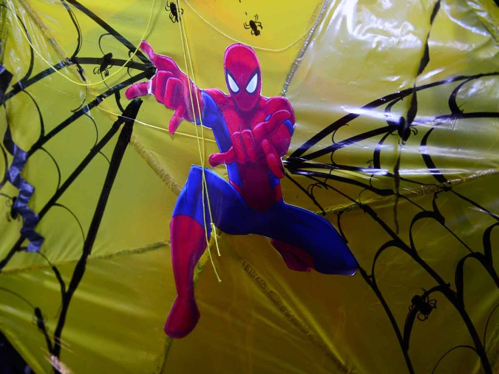Plano detalle del estampado de Spider-Man y telarañas sobre el plástico amarillo de una piscucha.