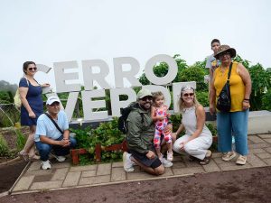 Grupo de turistas y familias posando sonrientes frente a las letras corpóreas del Parque Natural Cerro Verde.