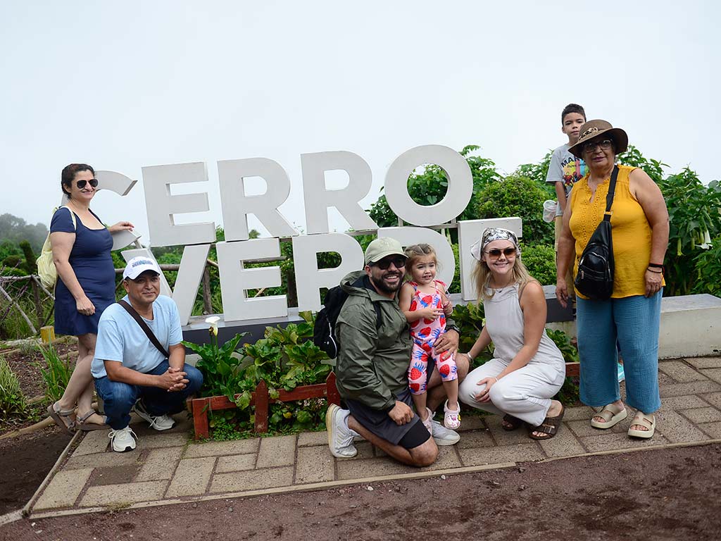 Grupo de turistas y familias posando sonrientes frente a las letras corpóreas del Parque Natural Cerro Verde.