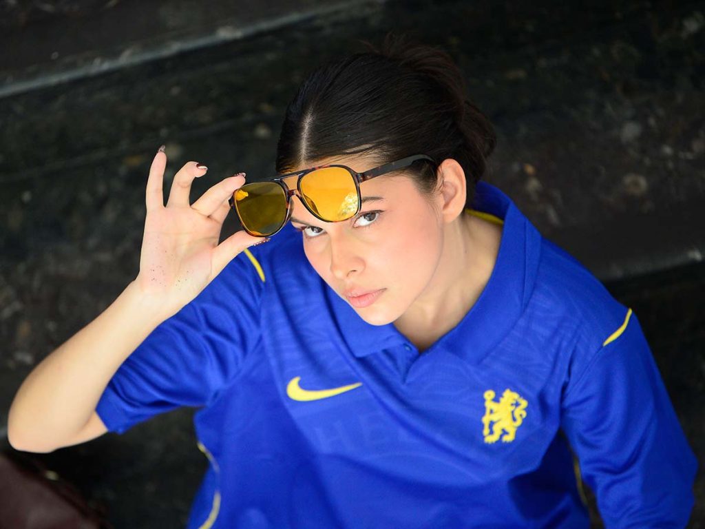 Retrato en ángulo picado de la cantautora Gabriela Triste mostrando el diseño de sus lentes amarillos.