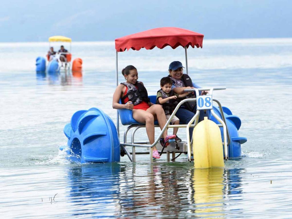 Familia disfrutando de un paseo en triciclo acuático con toldo en el Lago de Ilopango El Salvador