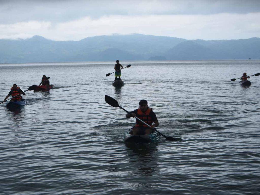 Grupo de personas haciendo kayak en las tranquilas aguas del Lago de Ilopango El Salvador