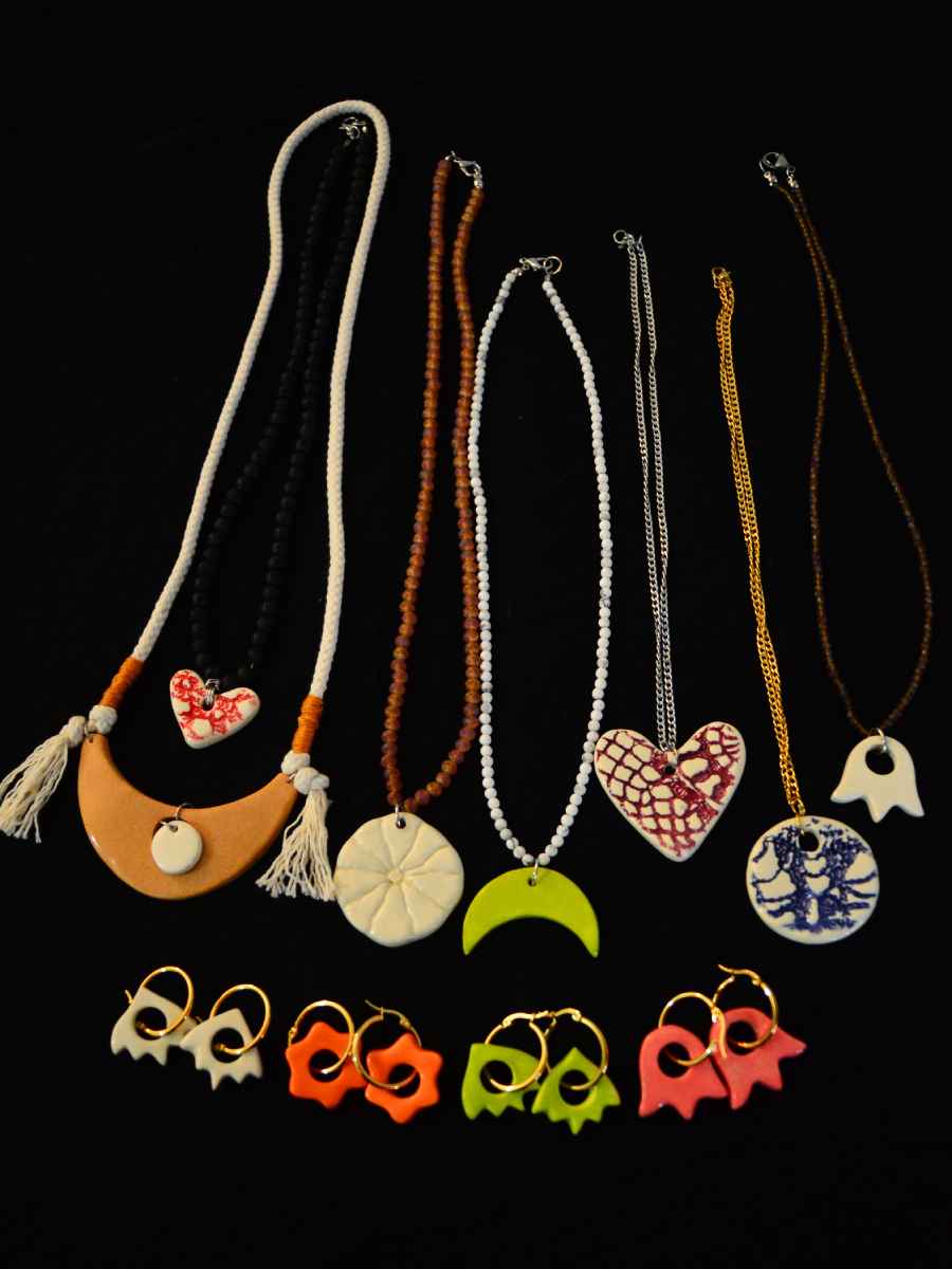 Fotografía de una cuidada selección de collares y aretes artesanales de cerámica hechos a mano por la diseñadora.