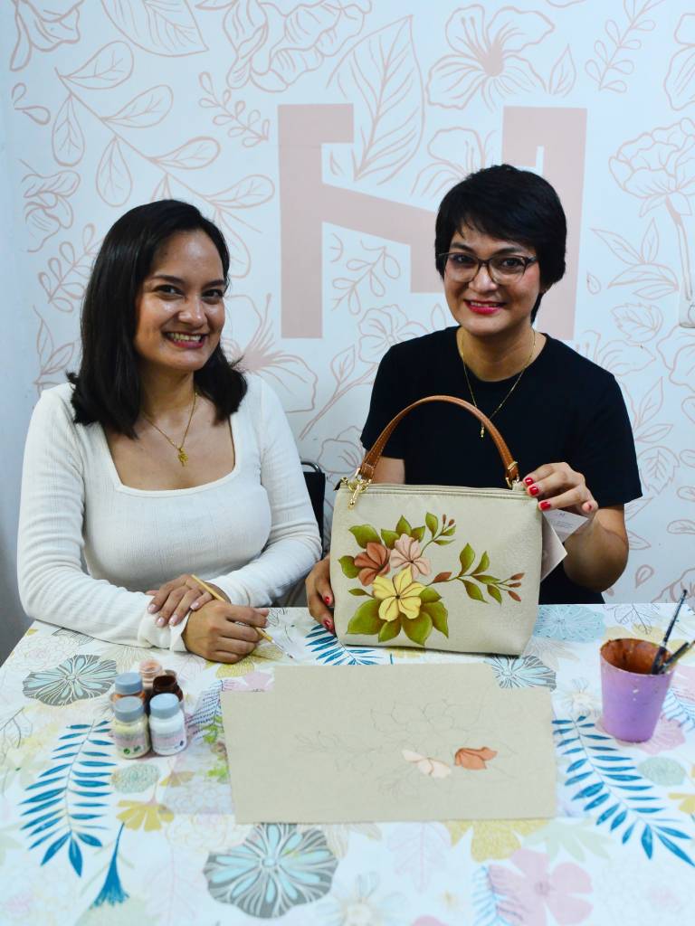 Nancy y Erika Herrera muestran a la cámara una cartera terminada durante la elaboración de contenido para sus plataformas.