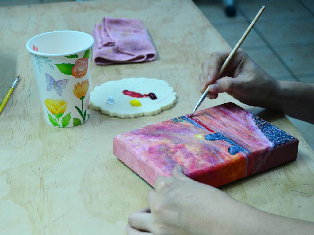 Gisela Herrera rodeada de sus primeros bocetos y obras de arte en el inicio de su trayectoria creativa.