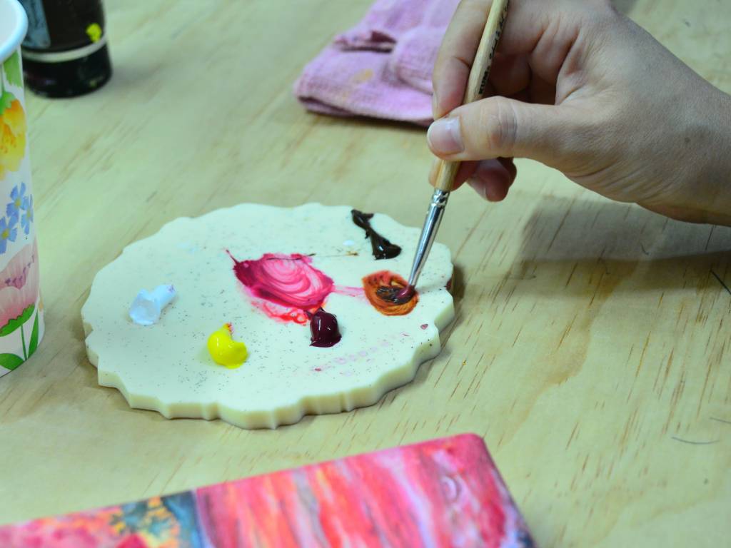 Gisela Herrera de pie frente a sus pinturas en su galería de arte en la colonia San Benito.