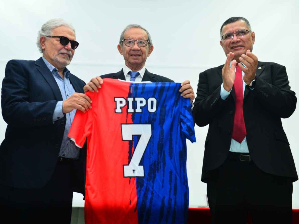 Pedro Valencia entrega una camiseta conmemorativa a «Pipo» Rodríguez junto al rector de la UES, Juan Rosa Quintanilla.