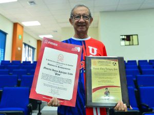 Mauricio «Pipo» Rodríguez sonríe al recibir un reconocimiento por su trayectoria en la Universidad de El Salvador.