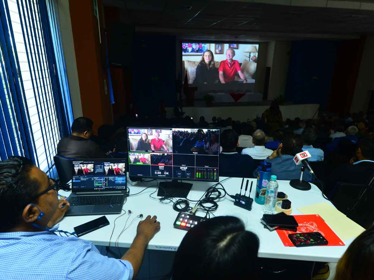 Pantalla del auditorio proyectando un video con imágenes históricas sobre la trayectoria de Mauricio «Pipo» Rodríguez.