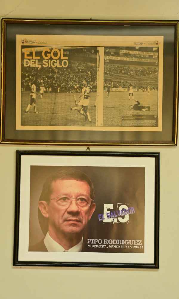 Cuadros enmarcados en la pared con recortes de prensa sobre «El Gol del Siglo» y un retrato de Mauricio «Pipo» Rodríguez.