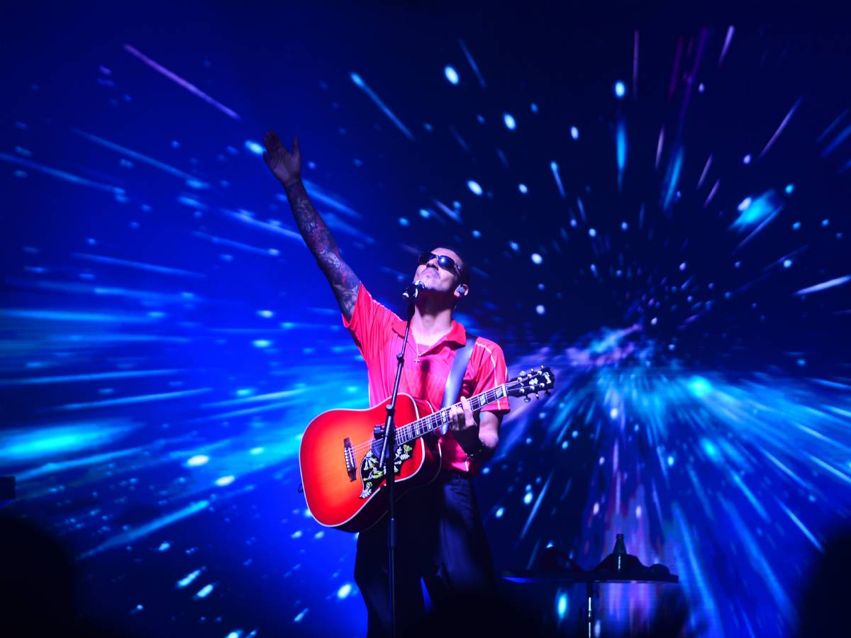 Fotografía del cantante Manuel Medrano en el escenario del complejo Be Sport en El Salvador, rodeado de luces y fans.