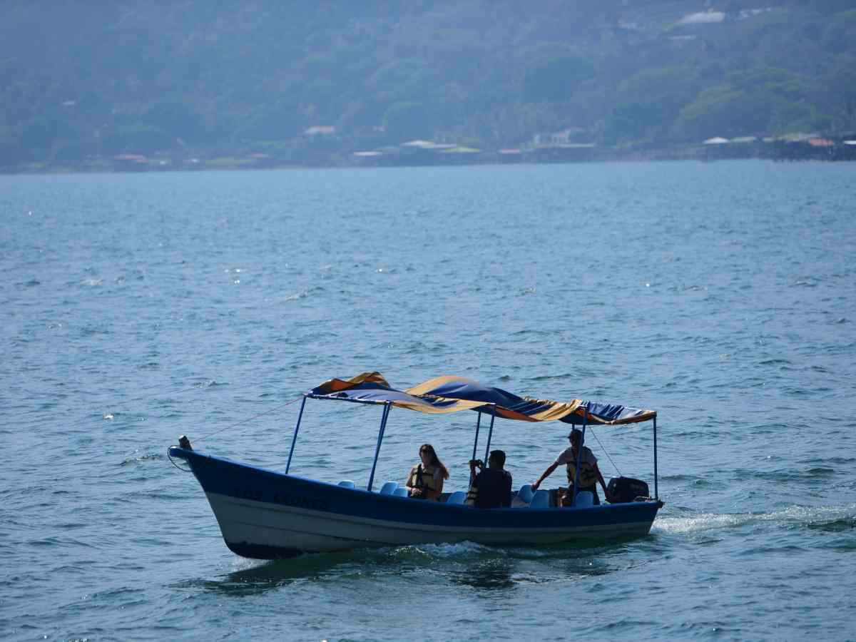 Las aguas del Lago de Coatepeque luciendo un deslumbrante tono verde turquesa rodeadas de exuberante vegetación.