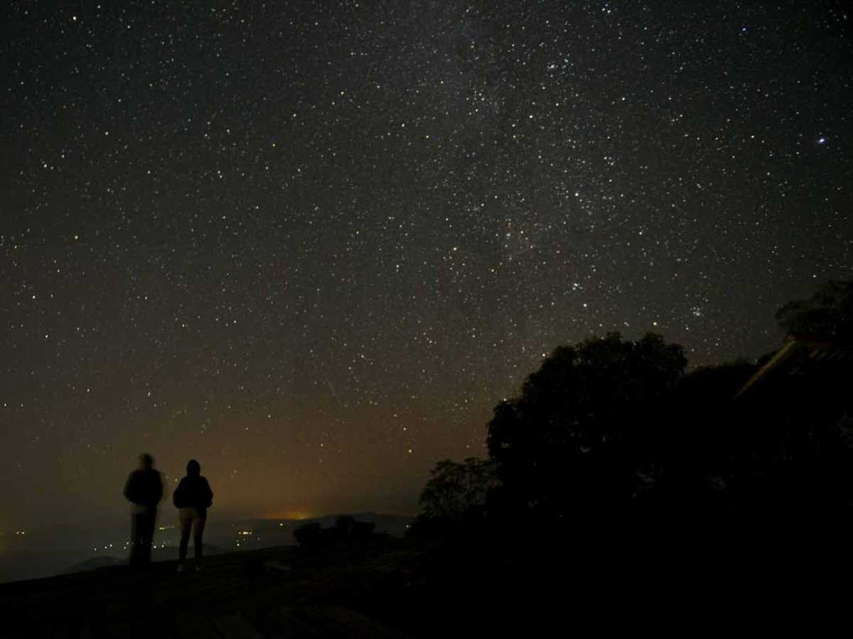 Vista nocturna del mirador El Espíritu de la Montaña en el Volcán de Conchagua durante una lluvia de estrellas.