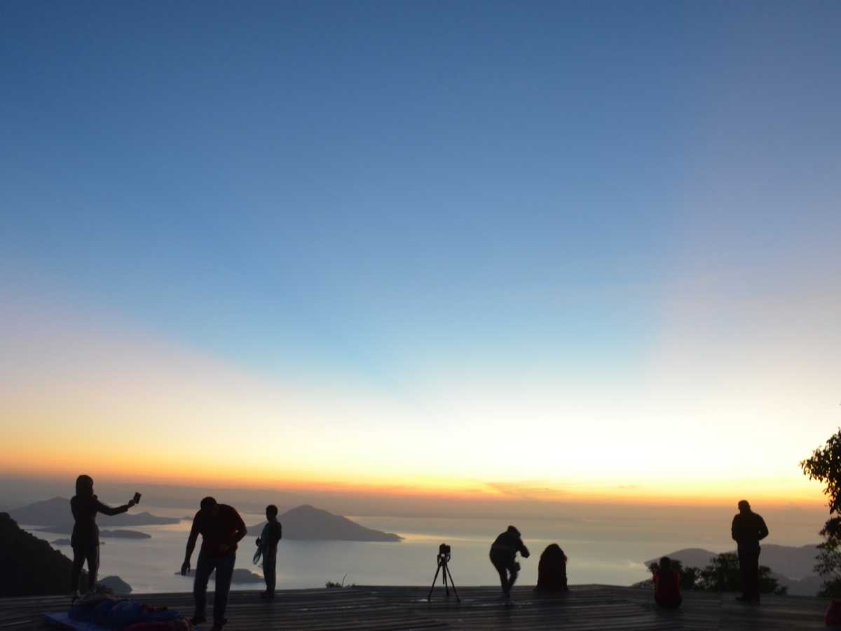 Salida del sol vista desde la cima del Volcán de Conchagua con tonos anaranjados sobre el horizonte.