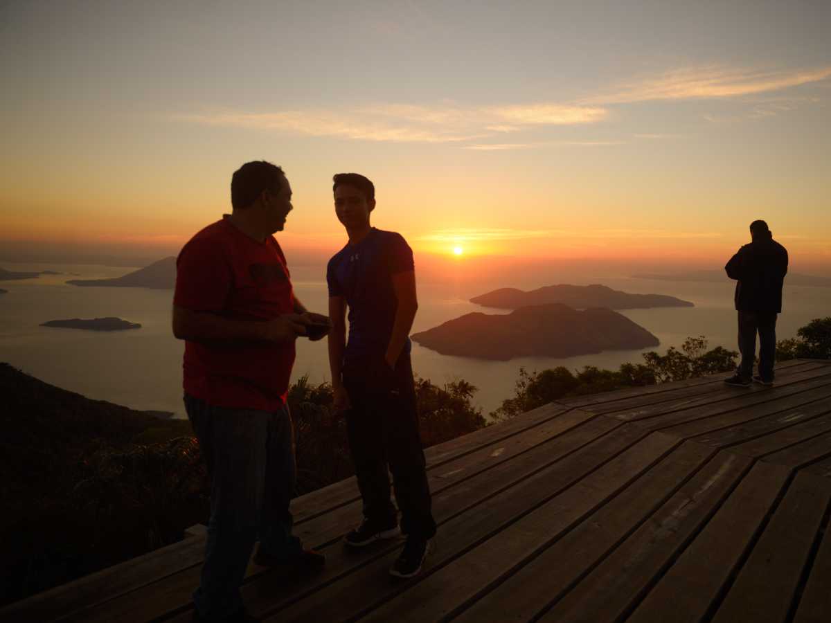Persona sobre la plataforma de madera del mirador Espíritu de la Montaña contemplando el golfo entre nubes.