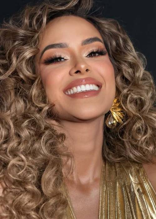 Luciana Sandoval luce un vestido brillante color dorado y el cabello rizado durante la gala del programa Yo me llamo.