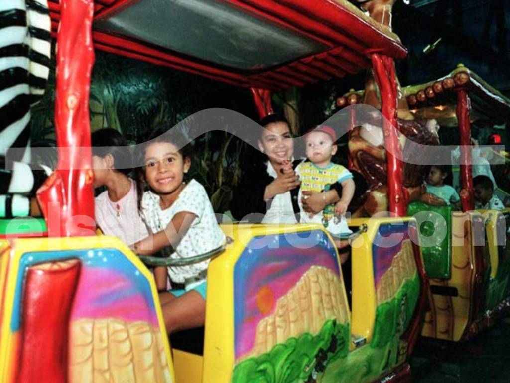 Niños disfrutando de los modernos juegos mecánicos en el interior del parque de diversiones.
