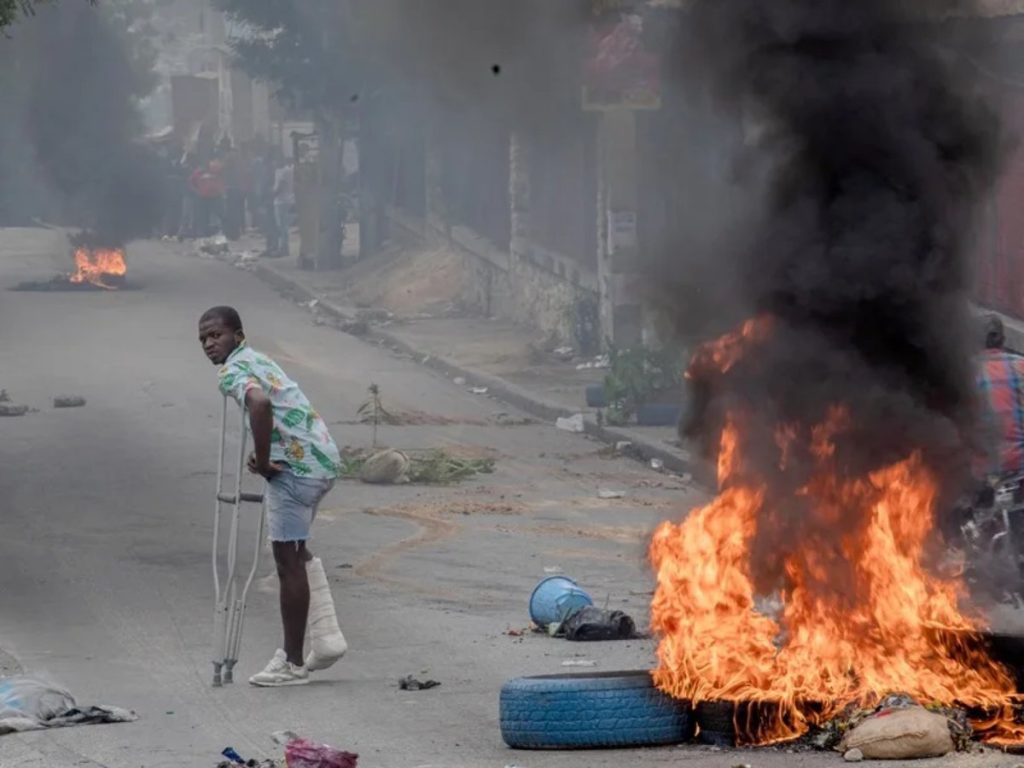 Un hombre camina por una calle bloqueada por manifestantes en Puerto Príncipe (Haití).