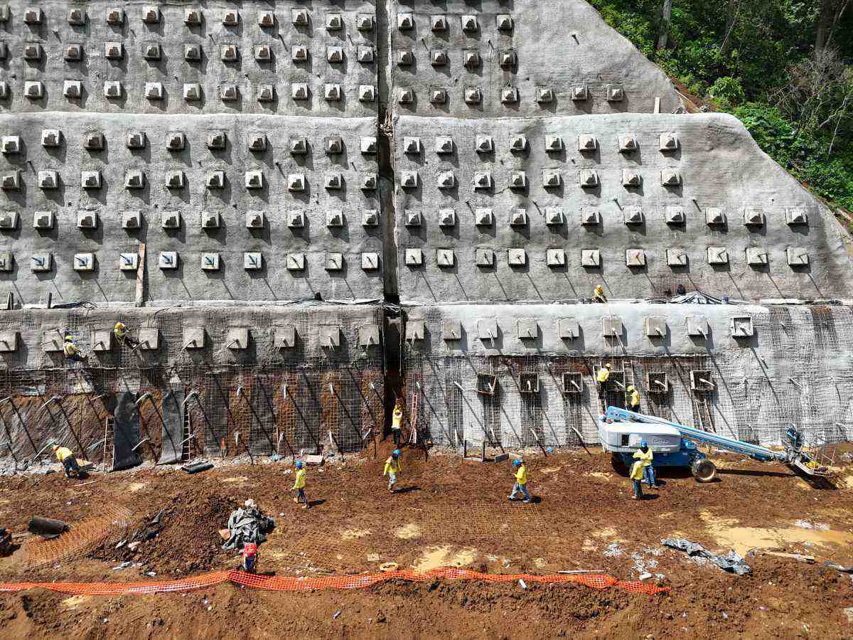 Inspector de obra revisando una losa de concreto con carpeta en mano.