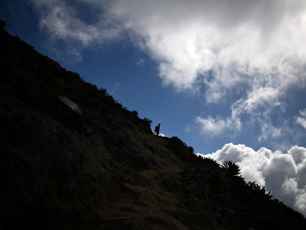 Grupo de senderistas recorriendo el sendero hacia el cráter del volcán bajo la supervisión de guías autorizados.
