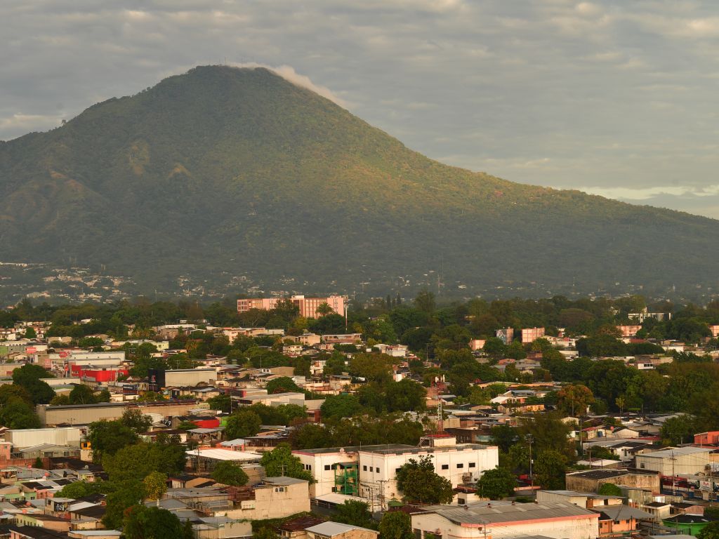 El volcán de San Salvador se viste de verde claro mientras la mañana ilumina completamente la urbe.