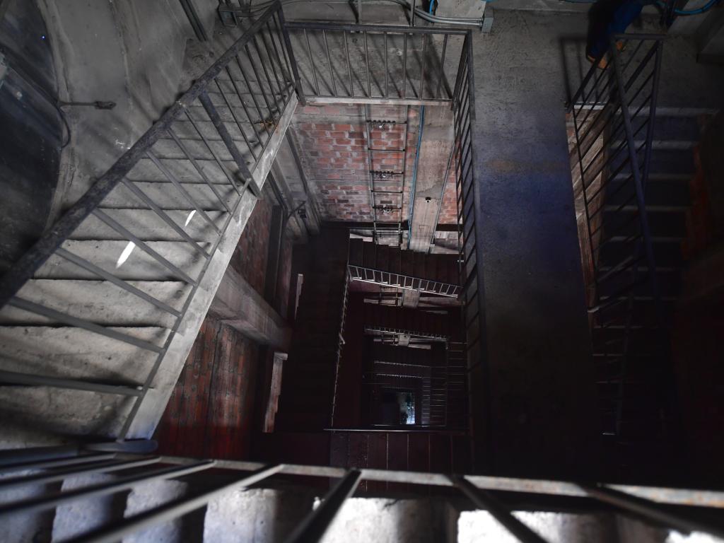 Una perspectiva descendente que revela la profundidad y las texturas de ladrillo de la escalera interior.