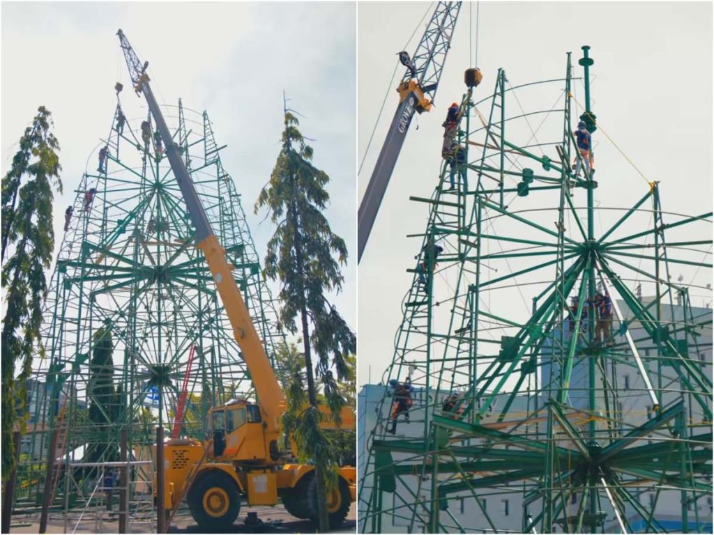 Trabajadores continúan instalando las piezas de la estructura navideña con apoyo de maquinaria.