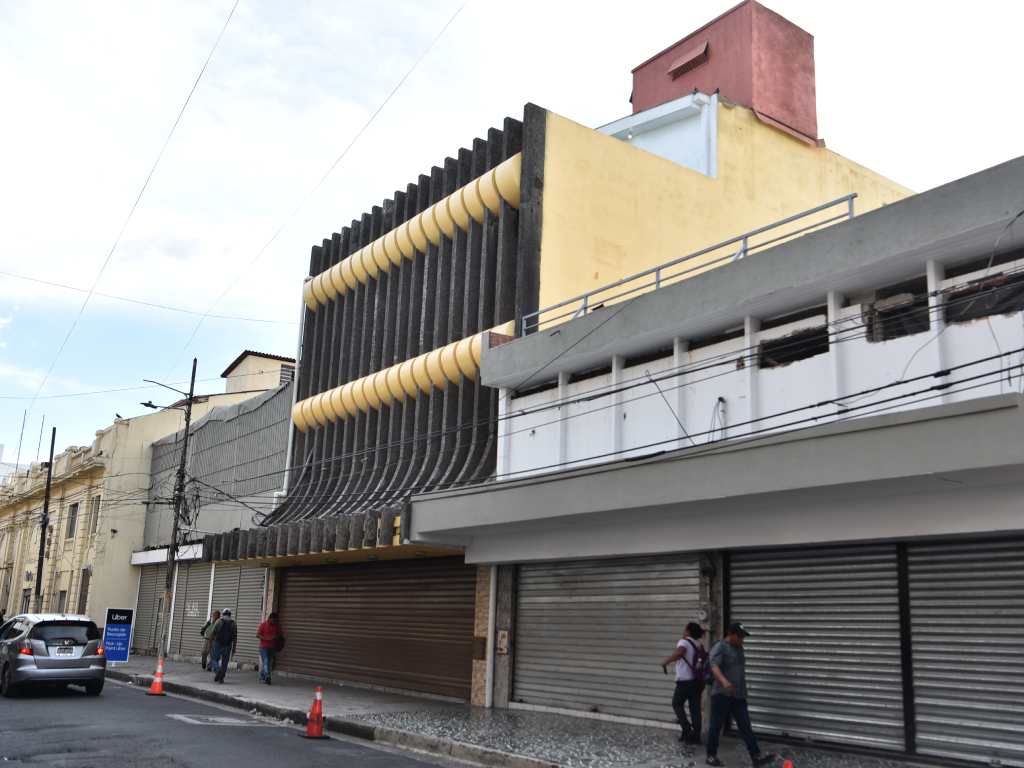 Vista de la calle del antiguo almacén Bigit, mostrando su fachada única de brise-soleil curvos y su entorno urbano.