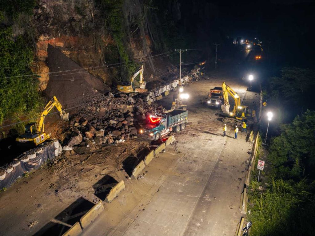 Maquinaria pesada retira las rocas y los escombros desprendidos del talud tras las explosiones controladas.