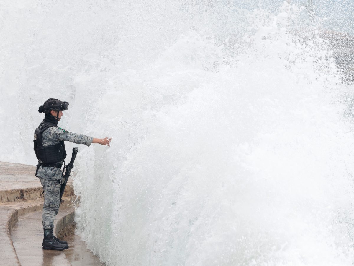 Un miembro de la Guardia Nacional de México permanece en el malecón de Puerto Vallarta mientras las olas rompen contra la costa ante el posible impacto del huracán Simón en Puerto Vallarta, estado de Jalisco, México, el 11 de octubre de 2026.