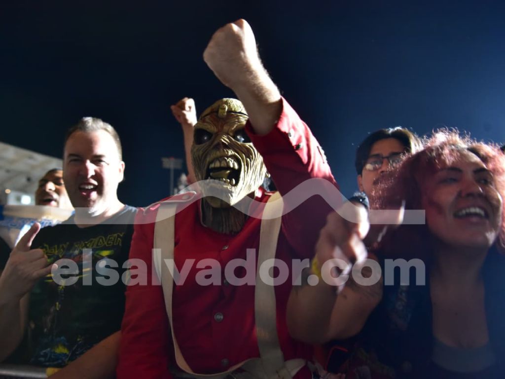 Fanáticos caracterizados como la mascota de la banda ovacionan el espectáculo desde la primera fila.