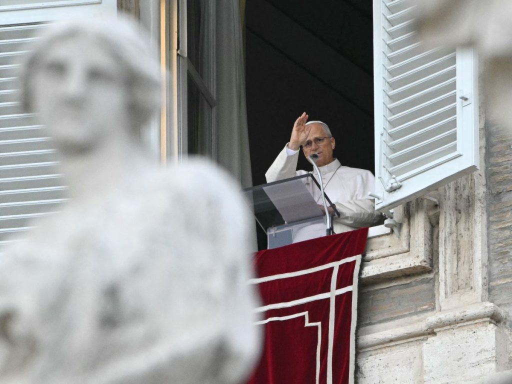 El papa León XIV bendice a la multitud desde la ventana del palacio apostólico con vistas a la plaza de San Pedro durante el rezo del Ángelus, un día después de su regreso al Vaticano tras una operación para extirpar un tumor canceroso en su pulmón derecho, el 18 de octubre de 2026. (Foto de Andreas SOLARO / AFP)
