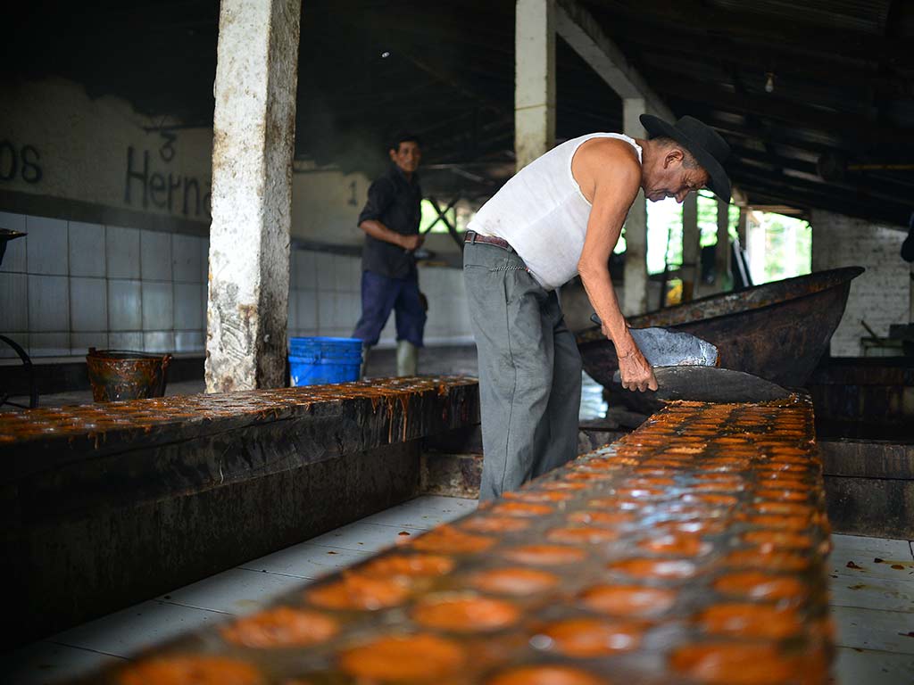 Vista en detalle de las cavidades cilíndricas en bloque de madera para dar forma al dulce de atado.