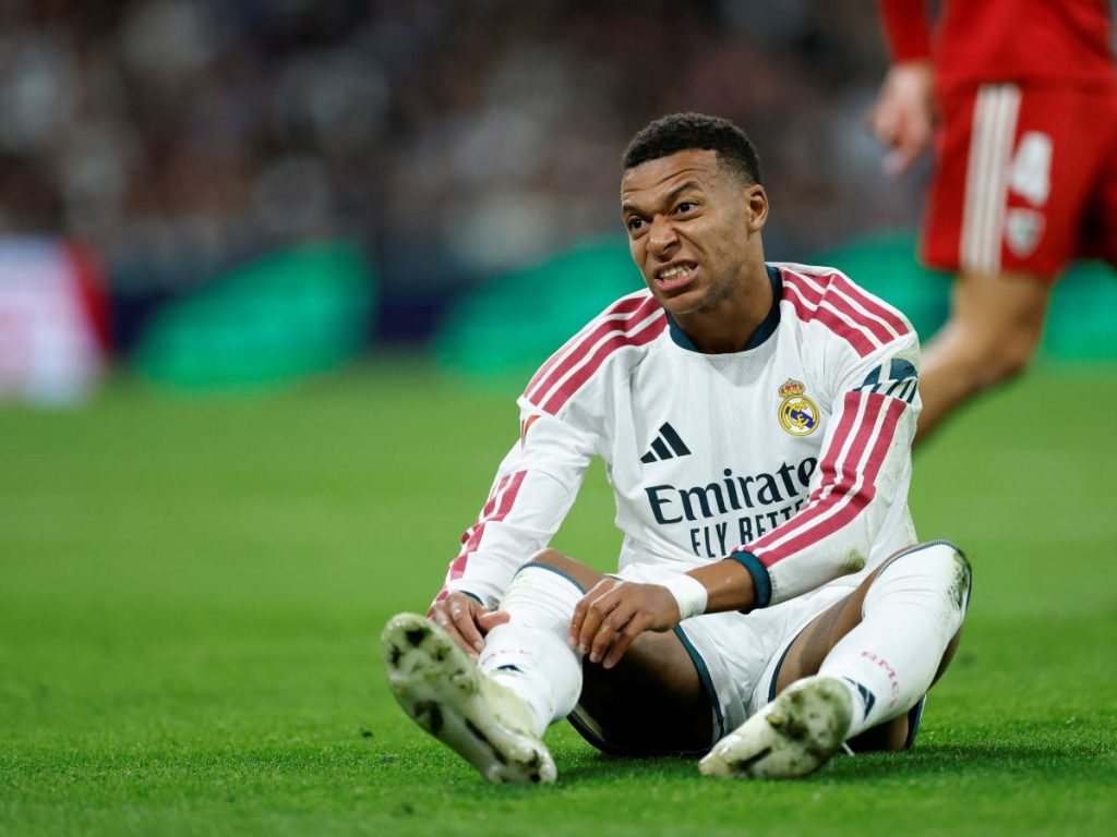 El delantero francés del Real Madrid, Kylian Mbappé, con el número 10, reacciona en el suelo durante el partido de la liga española entre el Real Madrid CF y el Sevilla FC en el estadio Santiago Bernabéu de Madrid, el 18 de octubre de 2026. (Foto de Oscar DEL POZO / AFP)