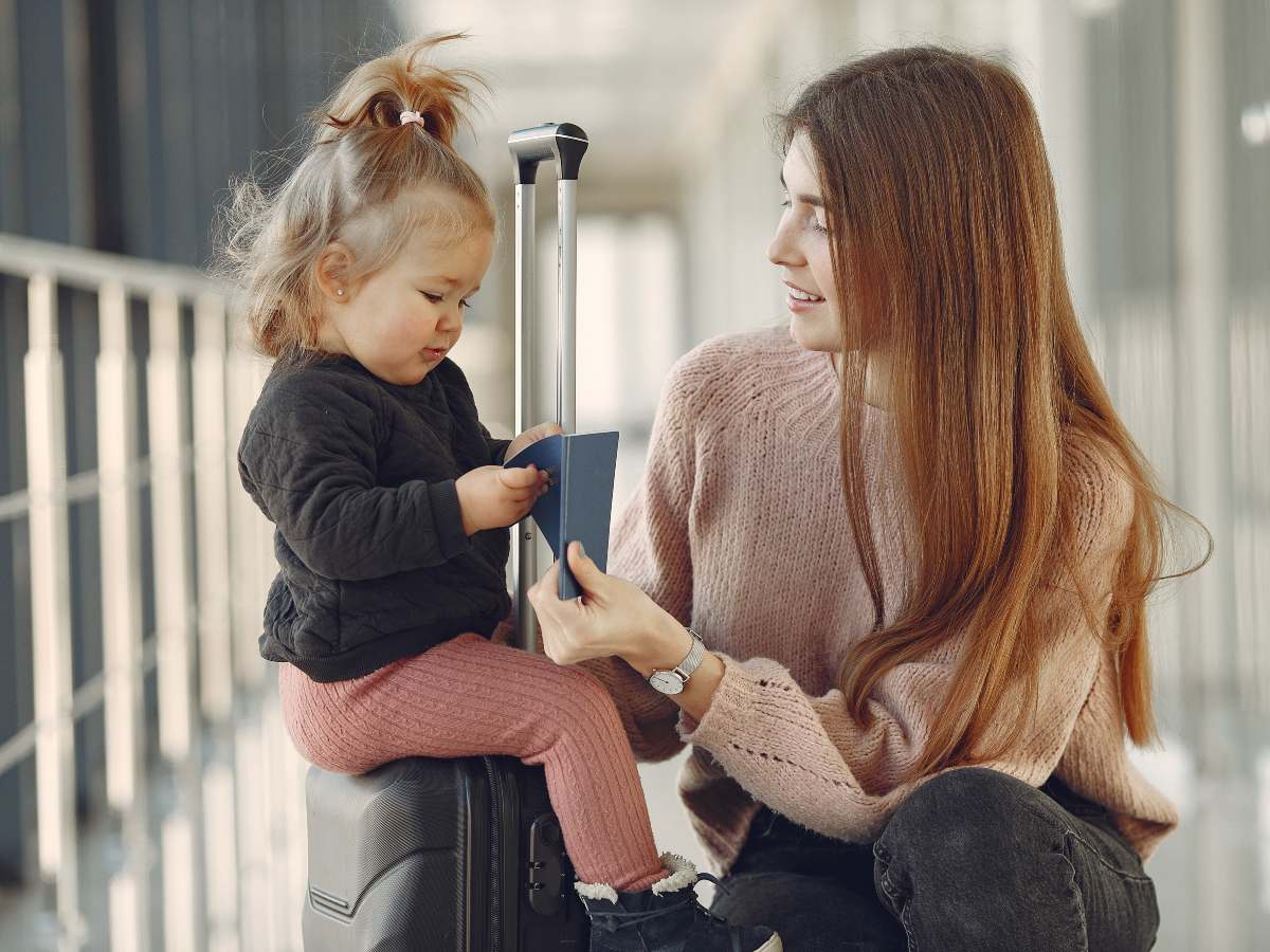 Family at the airport. Mother with daughter. Woman with suitcase.